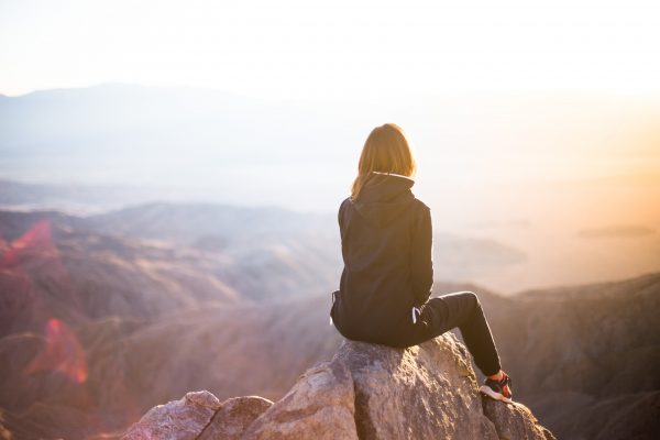 Woman sitting on a mountain looking to the distance