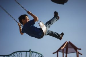 Young boy swinging on fairground ride
