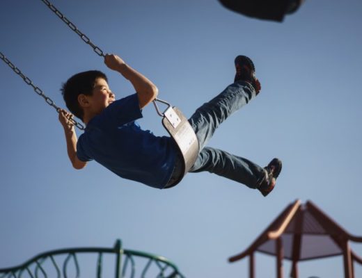 Young boy swinging on fairground ride