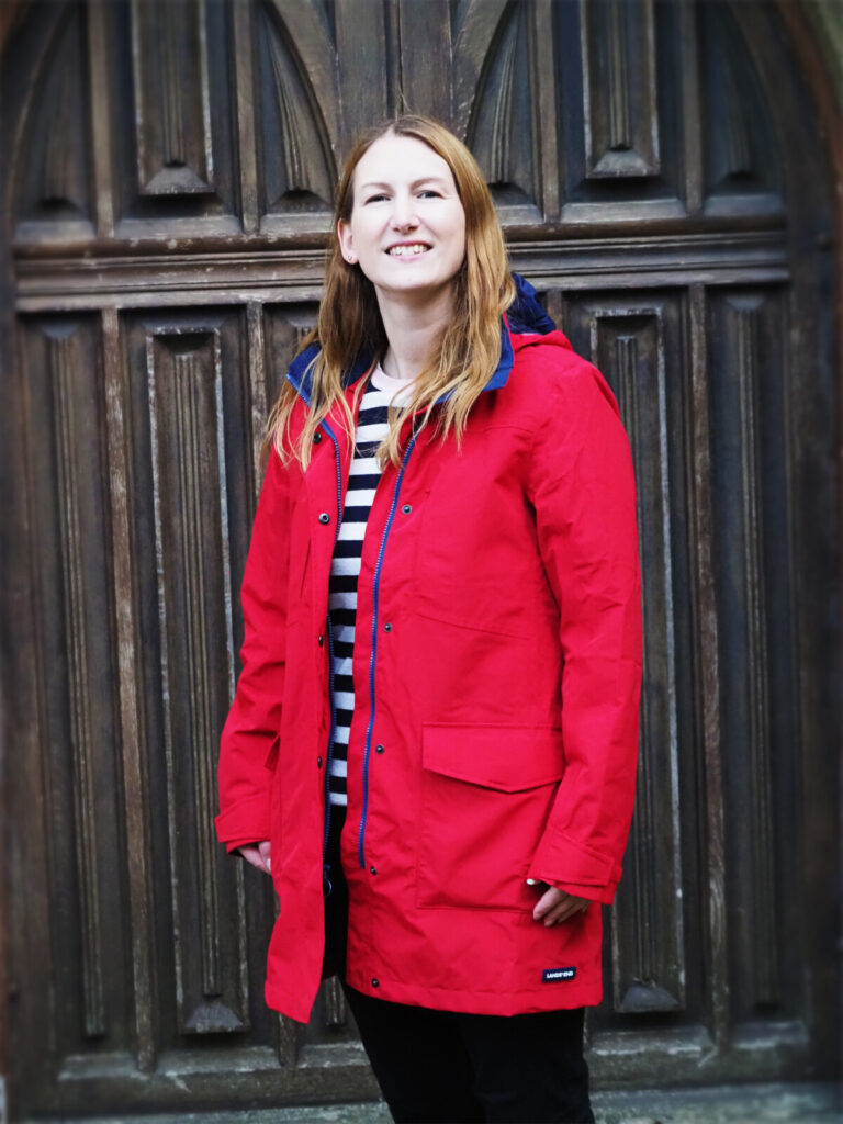 Women standing in front of church door in bright red jacket
